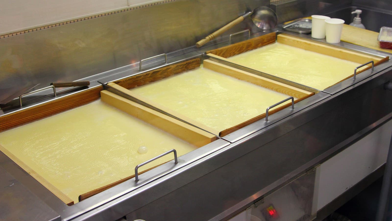 A tofu skin production vat used to discuss line scale and tray layout