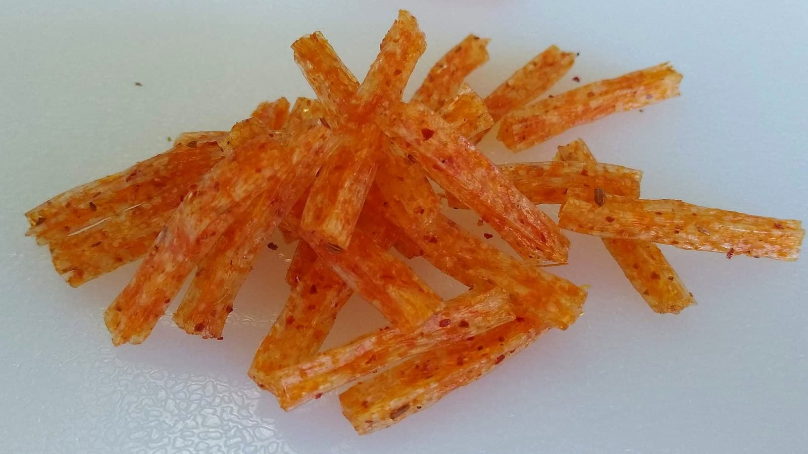Latiao strands coated in deep red chili oil for spice-level comparison